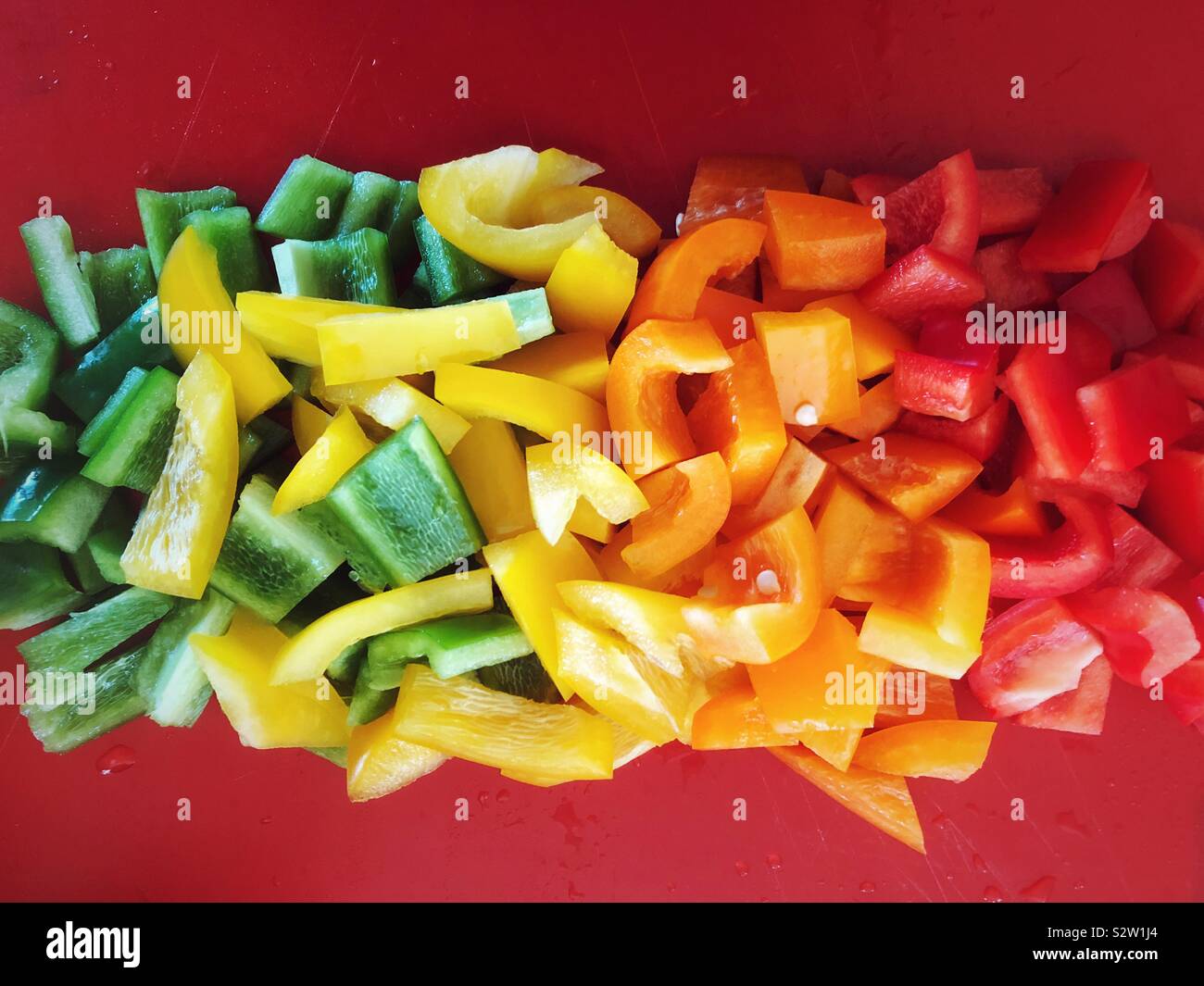 Frisch gewaschene und gehackte grün, gelb, orange und rote Paprika Stockfoto
