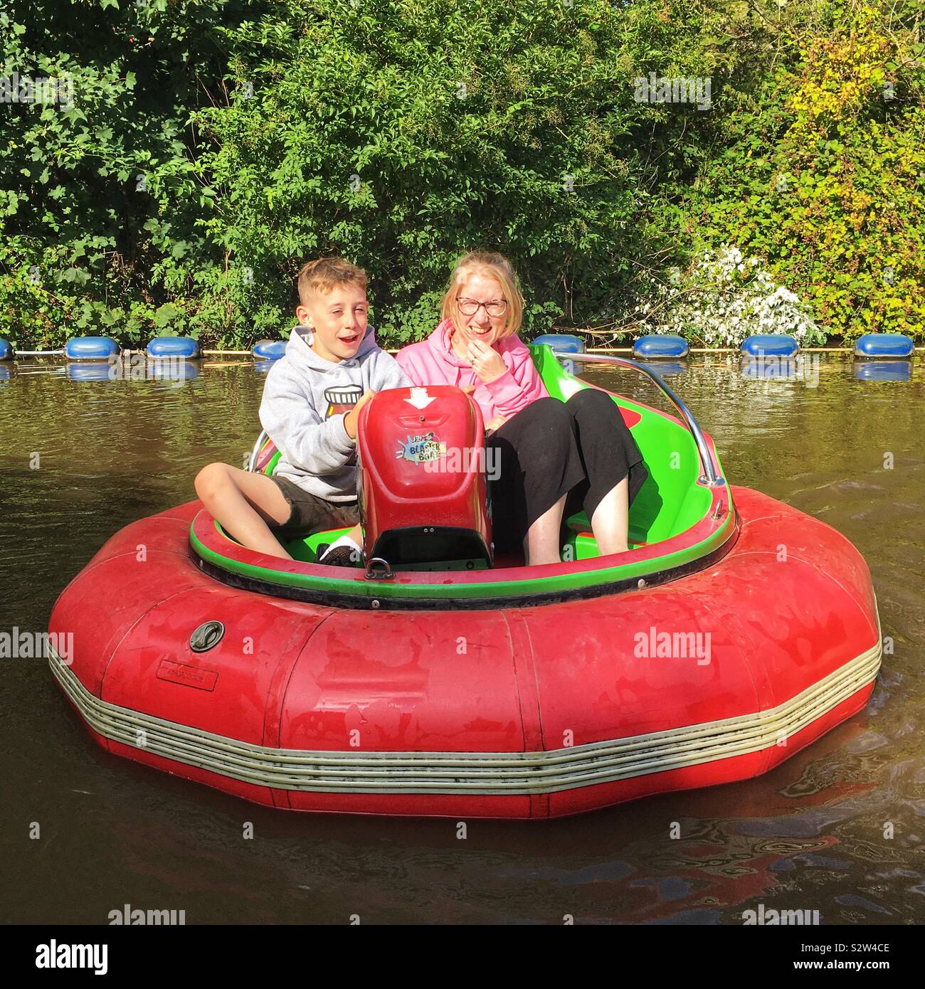 Mutter und Sohn am Stoßfänger Boote bei Waldland Family Theme Park, Totnes, Devon, England, Vereinigtes Königreich. Stockfoto