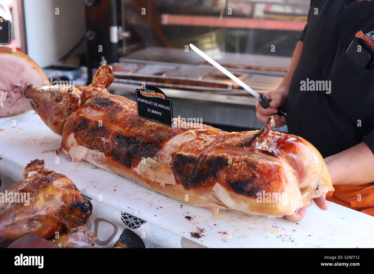 Ein Schwein Metzger wird ein Rost Ferkel für einen Client Schnitt Stockfoto