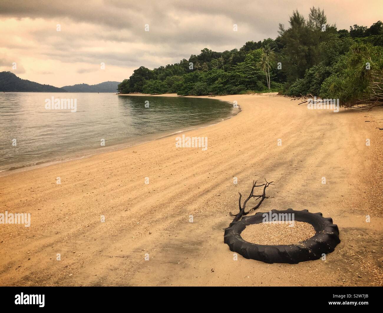 Ein Reifen halb als Verankerungspunkt für Boote am Strand begraben, manjung Flussmündung, in der Nähe von Lumut, Perak, Malaysia - Smartphone-aufgenommenes Stockfoto
