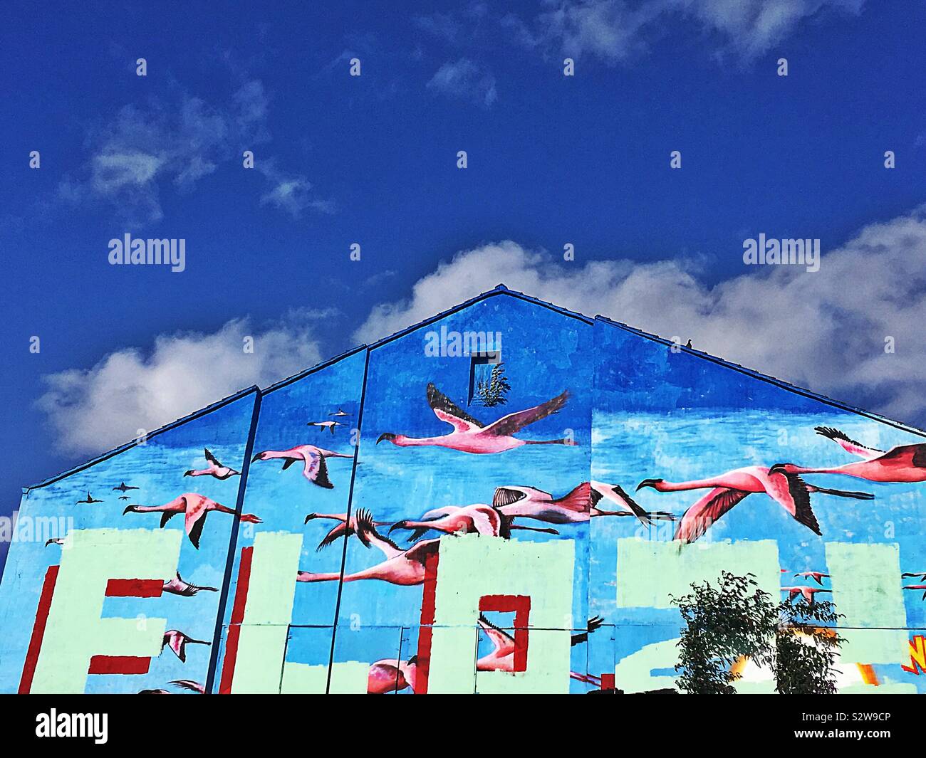 Blaues Gebäude mit Graffiti auf gegen den strahlend blauen Himmel. Liverpool Ostsee Dreieck Stockfoto