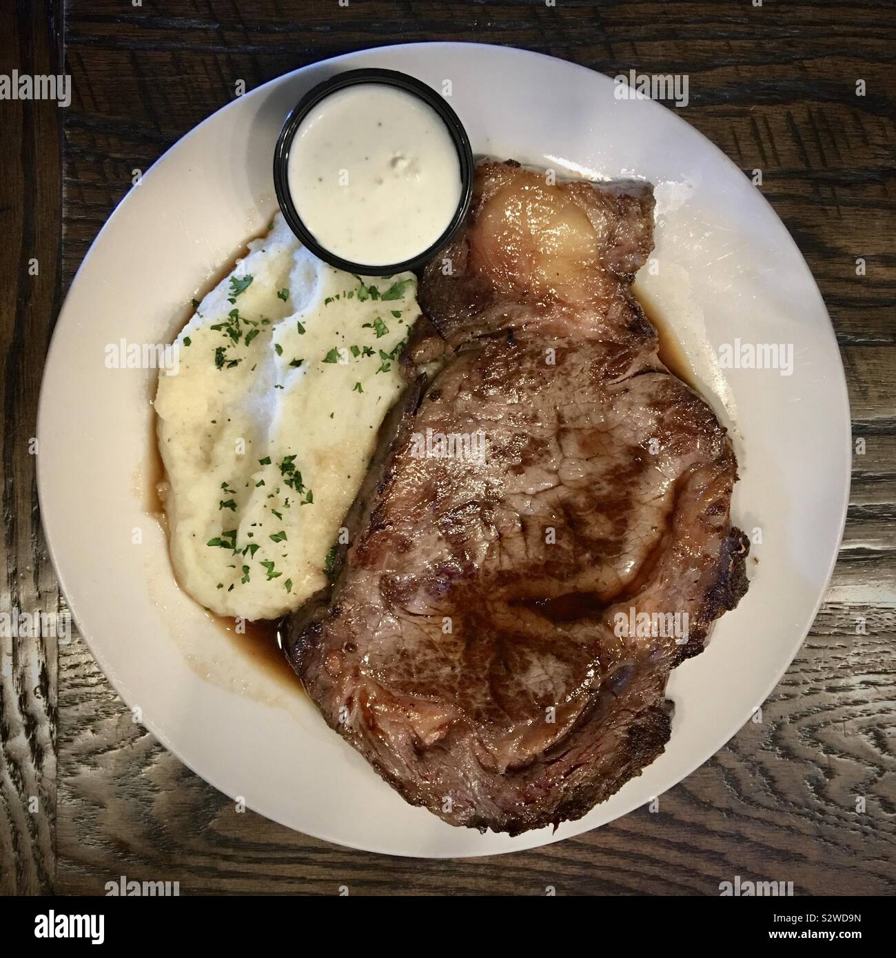 Ansicht von oben mit steak, Kartoffelpüree und Meerrettich Sauce auf weiße Platte - Smartphone-aufgenommenes Stockfoto