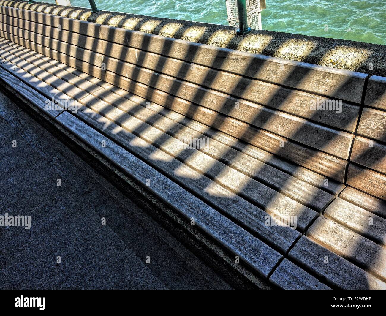 Schatten auf einer Sitzbank auf Deal Pier - Smartphone-aufgenommenes Stockfoto