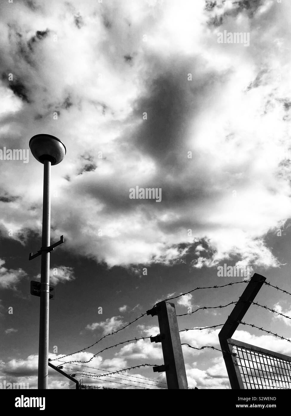 Stacheldrahtzaun und lampenlicht - Smartphone-aufgenommenes Stockfoto