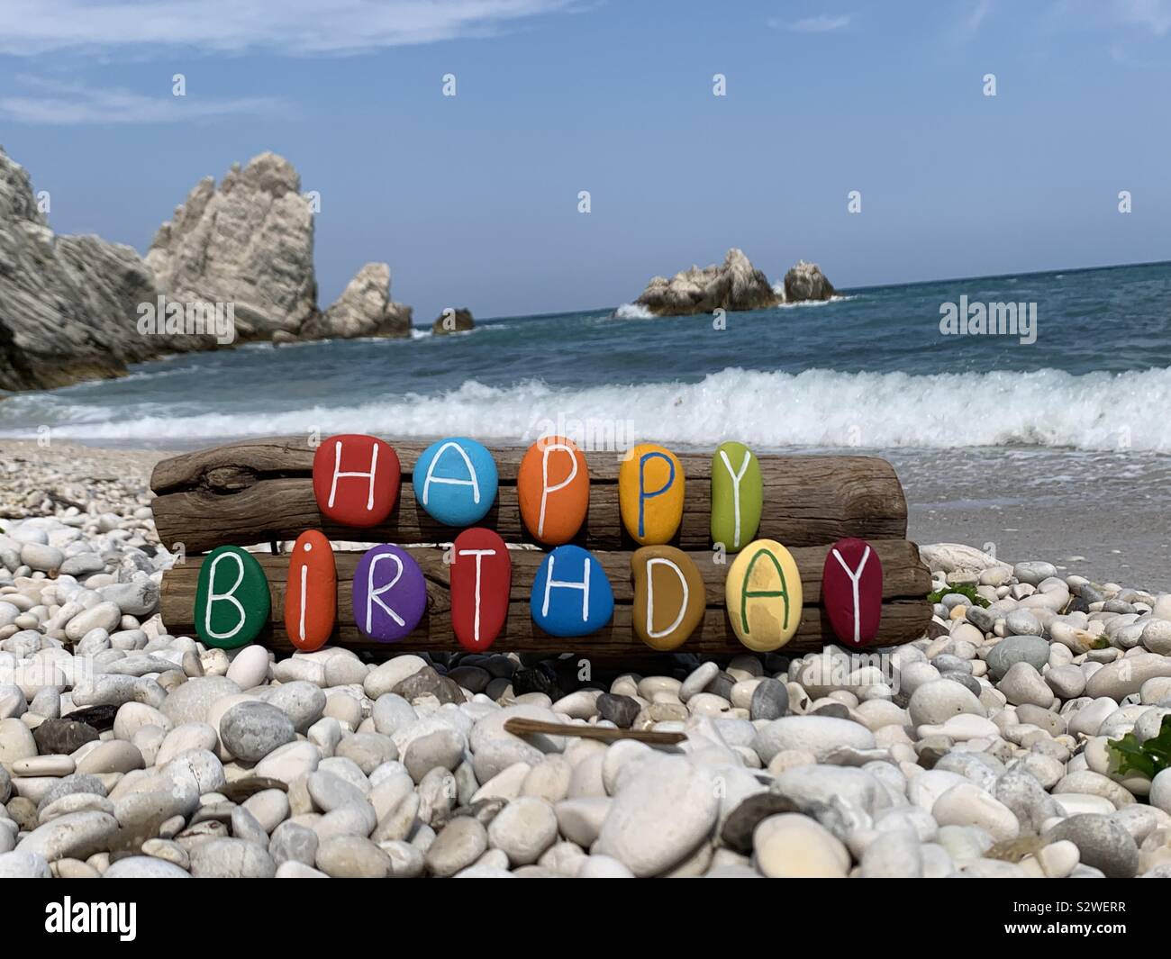 Geburtstag mit einem kreativen farbige Steine Kunstwerk am Strand - Smartphone-aufgenommenes Stockfoto