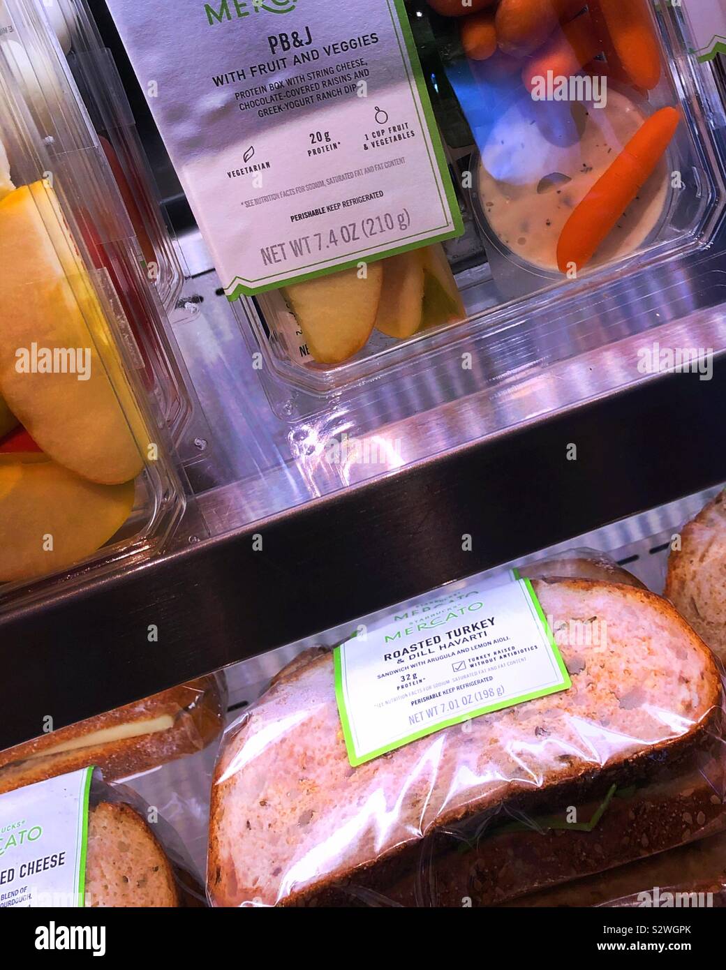 Fertige Sandwiches und Snacks Platten in ein Starbucks Anzeige Fall gestapelt. Stockfoto