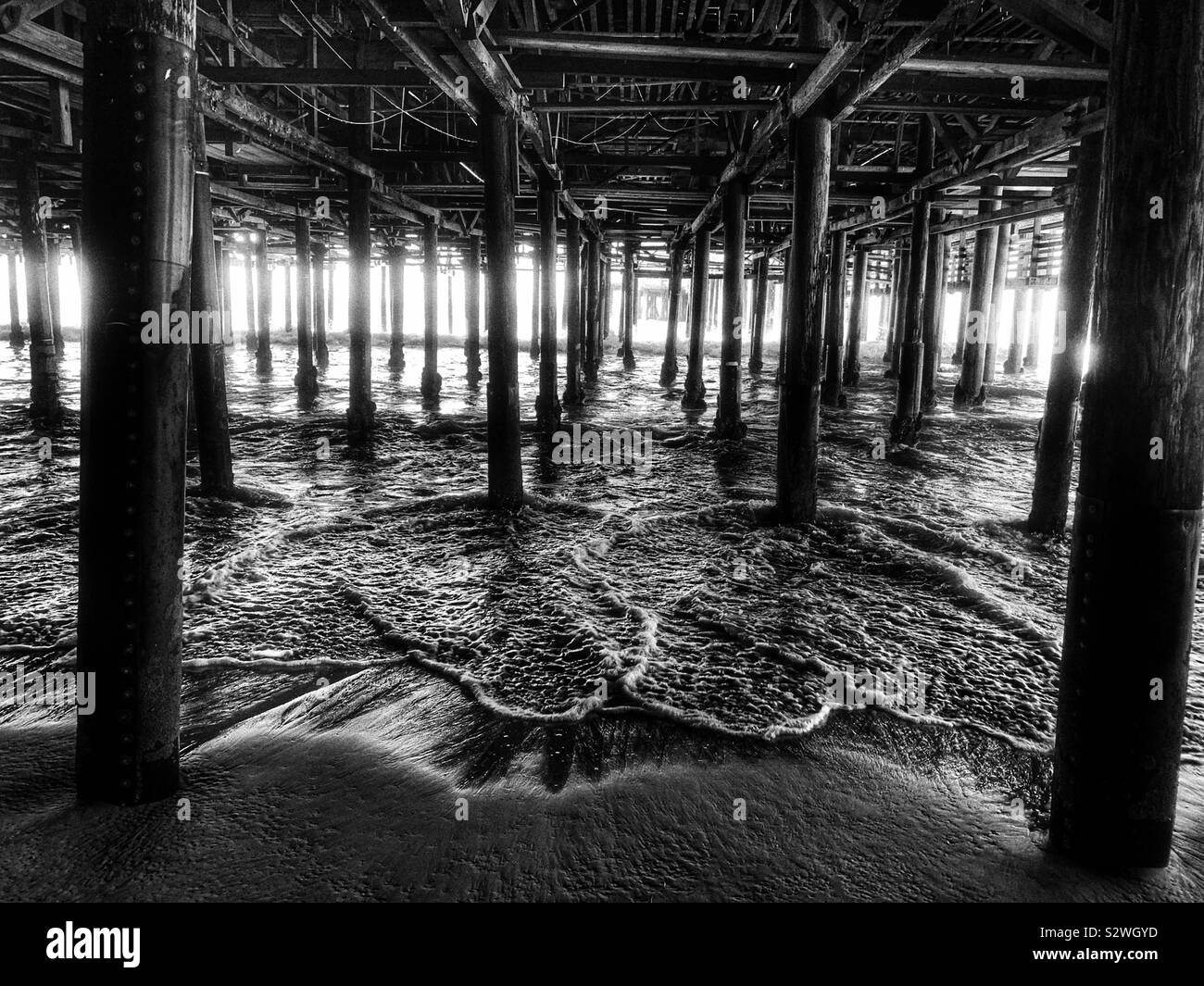 Unter dem Pier von Santa Monica, Kalifornien in Schwarz und Weiß Stockfoto