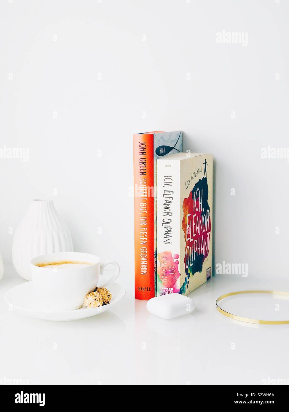 Weiß Top von Sideboard mit Bücher, Vasen, Kaffee, Kopfhörer und golden Zubehör eingerichtet Stockfoto