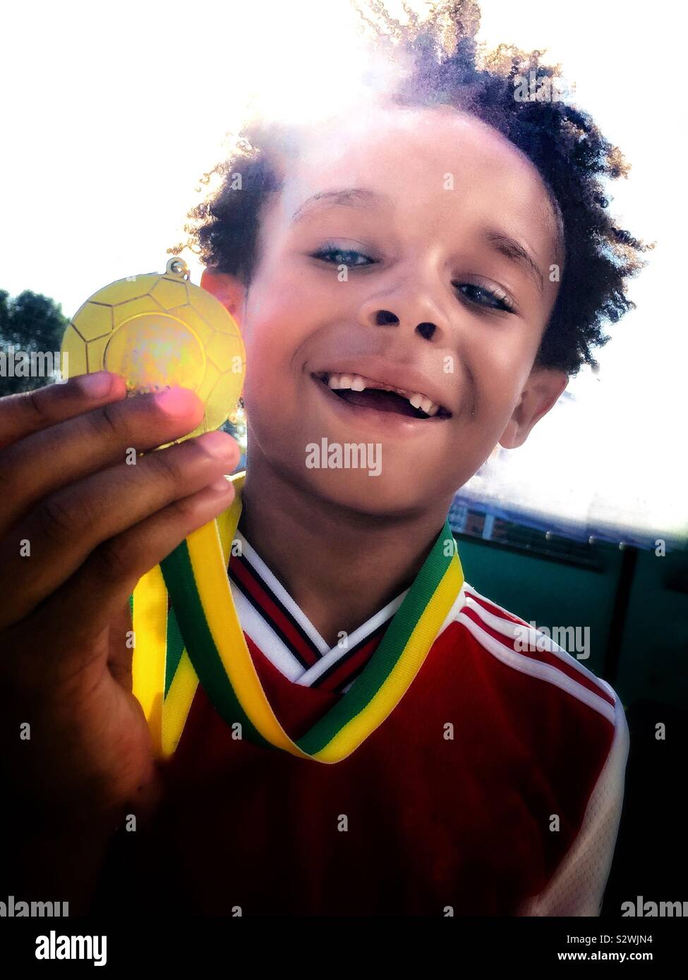 Ein Junge zeigt stolz seinen Sport Medaille. Stockfoto