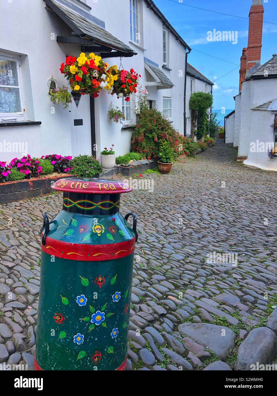 Dekoriert Milchkanne auf den gepflasterten Straße in Clovelly, North Devon. Stockfoto