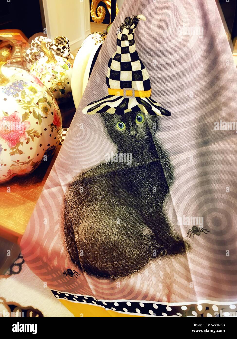 Halloween themed Handtuch mit einer schwarzen Katze trägt eine schwarz-weiß karierten Zauberer Hut. Mackenzie Childs, Soho, NEW YORK CITY, USA Stockfoto