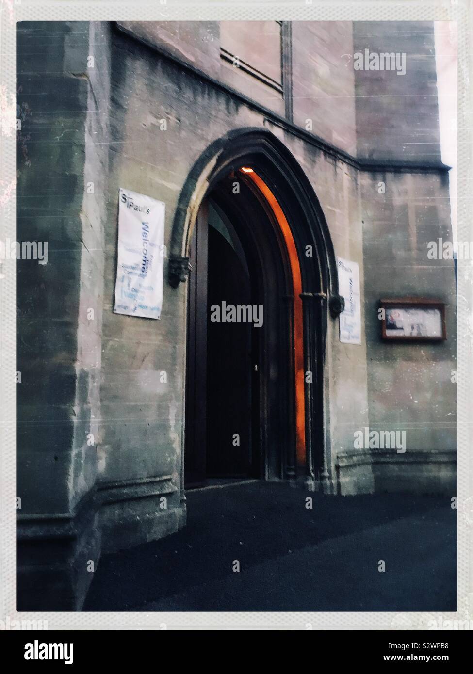 Offenen Tür einer Kirche, mit orange Licht von innen leuchtenden Um die Tür Stockfoto