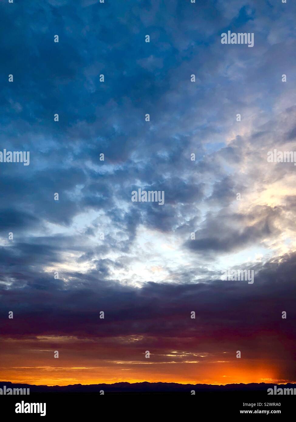 Bewölkt Sonnenaufgang hinter dunklen Berge Stockfoto