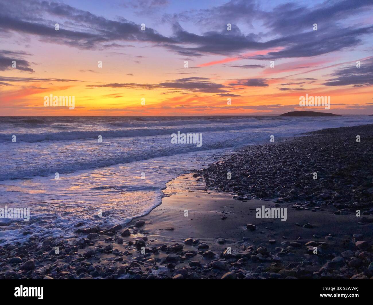 Sonnenuntergang abendrot am strand, mit llangennith Burry Halligen in der Ferne, Gower, Swansea, South West Wales, August. Stockfoto