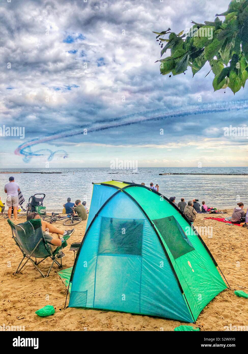 Am Strand beobachten die Air Show. - Smartphone-aufgenommenes Stockfoto