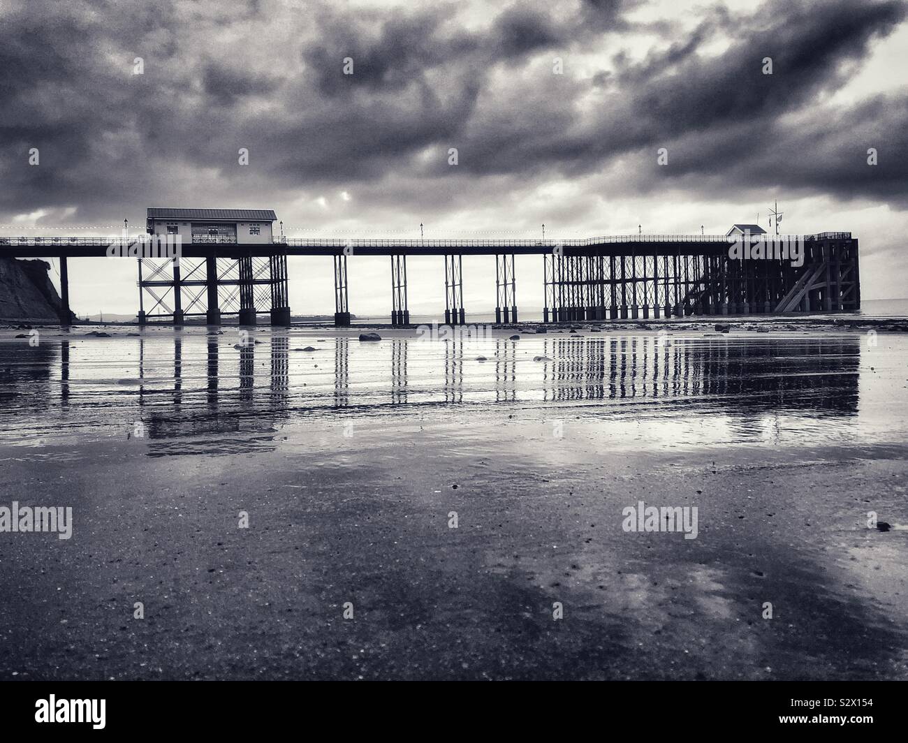 Penarth pier, Ebbe mit Reflexionen in feuchten Sand. South Wales. - Smartphone-aufgenommenes Stockfoto