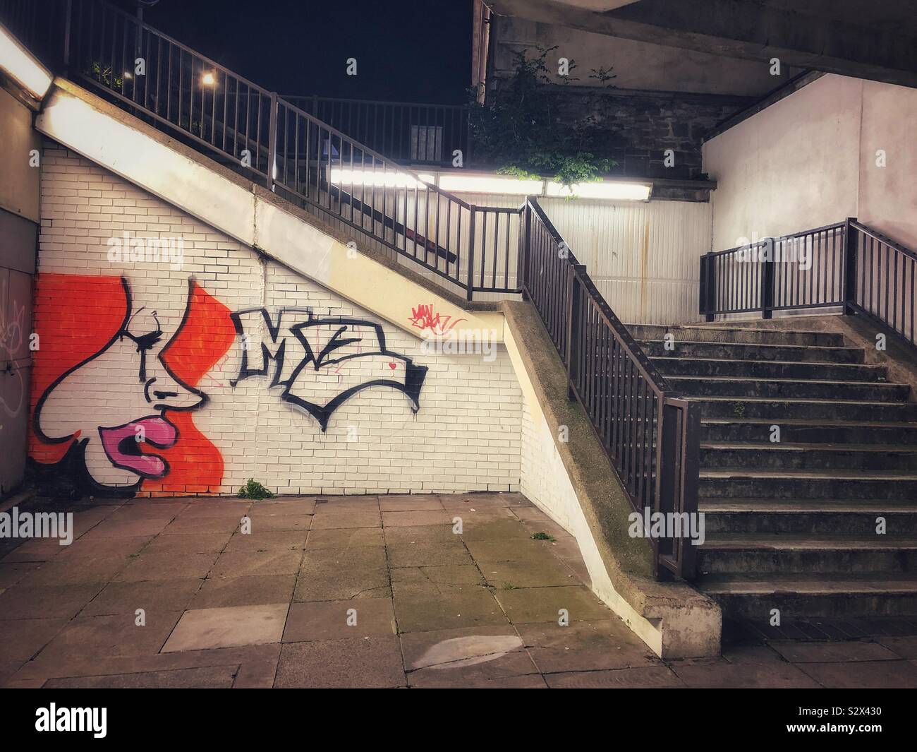 Graffiti auf einer U-Wand neben der Treppe, Cardiff. Stockfoto