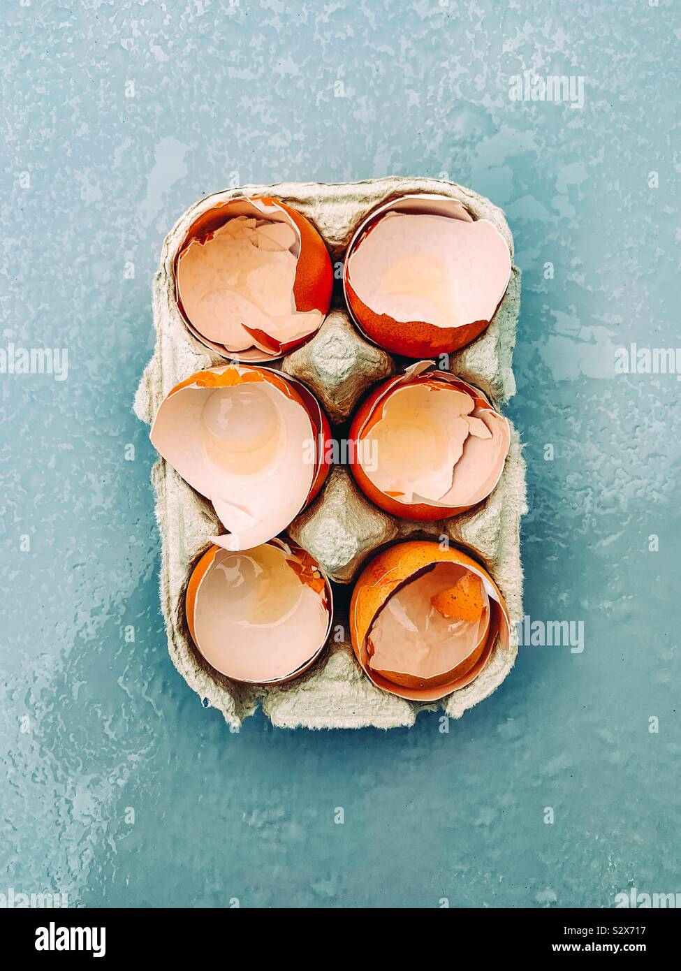 Sechs Eier in Container auf einem blauen Hintergrund geöffnet - Smartphone-aufgenommenes Stockfoto