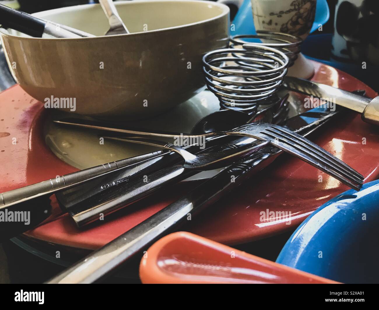 Schmutzige Teller, Schüsseln und Besteck stapelten sich auf, um sich abzuspülen. Stockfoto