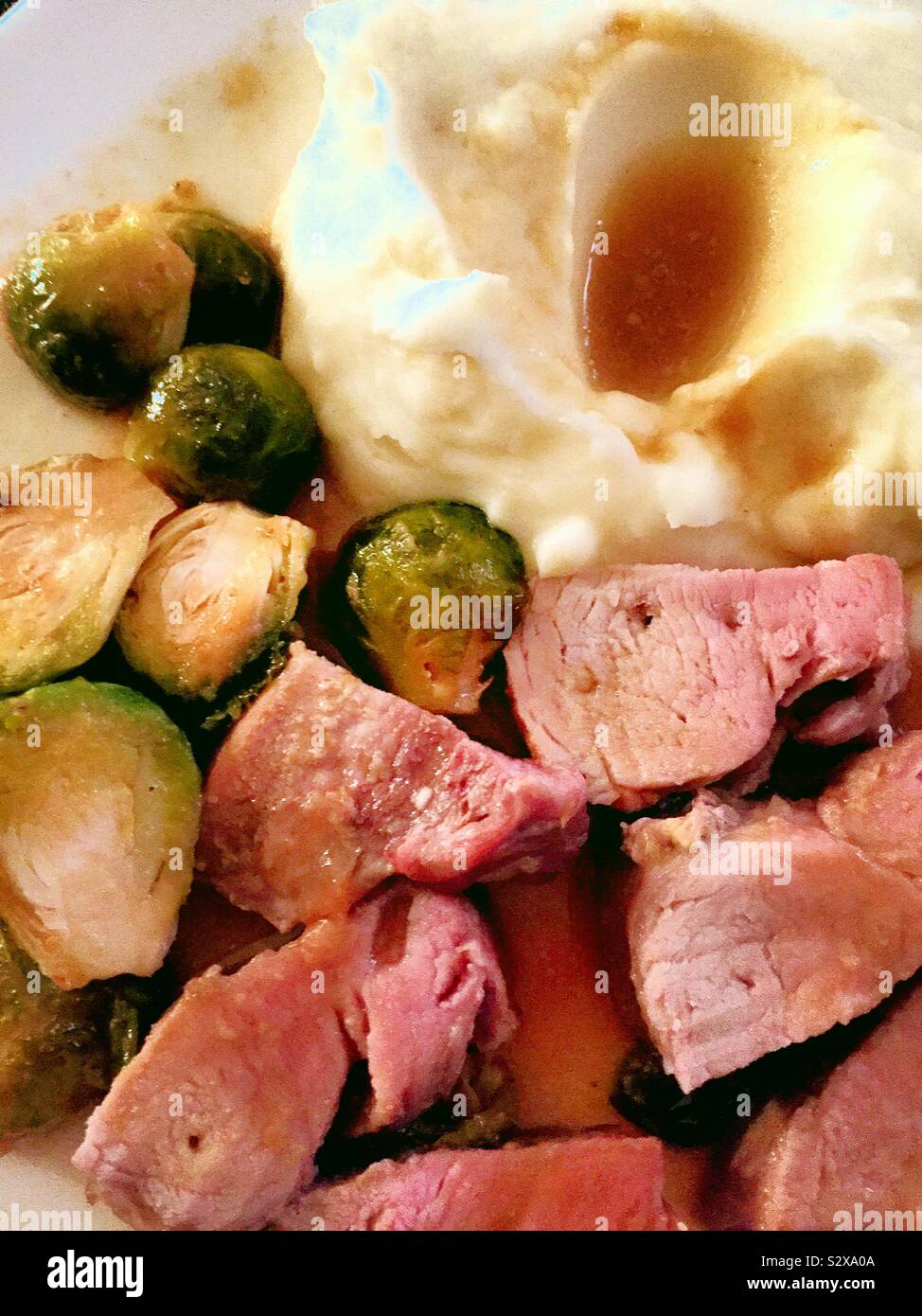 Home gekochte Mahlzeit von Schweinefilet, Rosenkohl, und gestampften Kartoffeln und Soße, USA - Smartphone-aufgenommenes Stockfoto