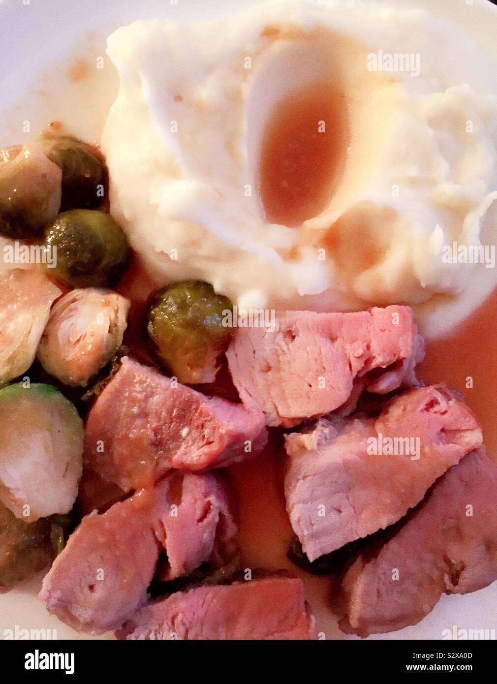 Herzhafte Klassiker Mahlzeit von Schweinefilet, Rosenkohl und Kartoffelbrei und Soße, USA - Smartphone-aufgenommenes Stockfoto