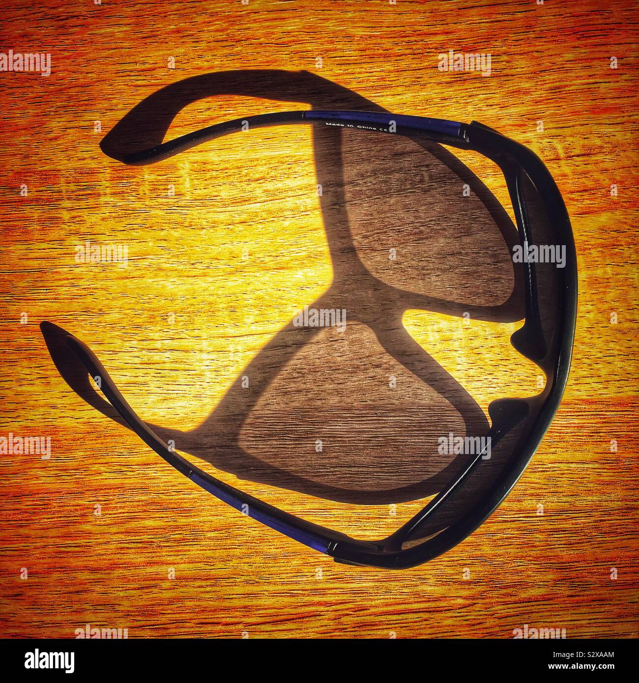 Schattenspiel von Sonnenbrillen auf Tisch Stockfoto