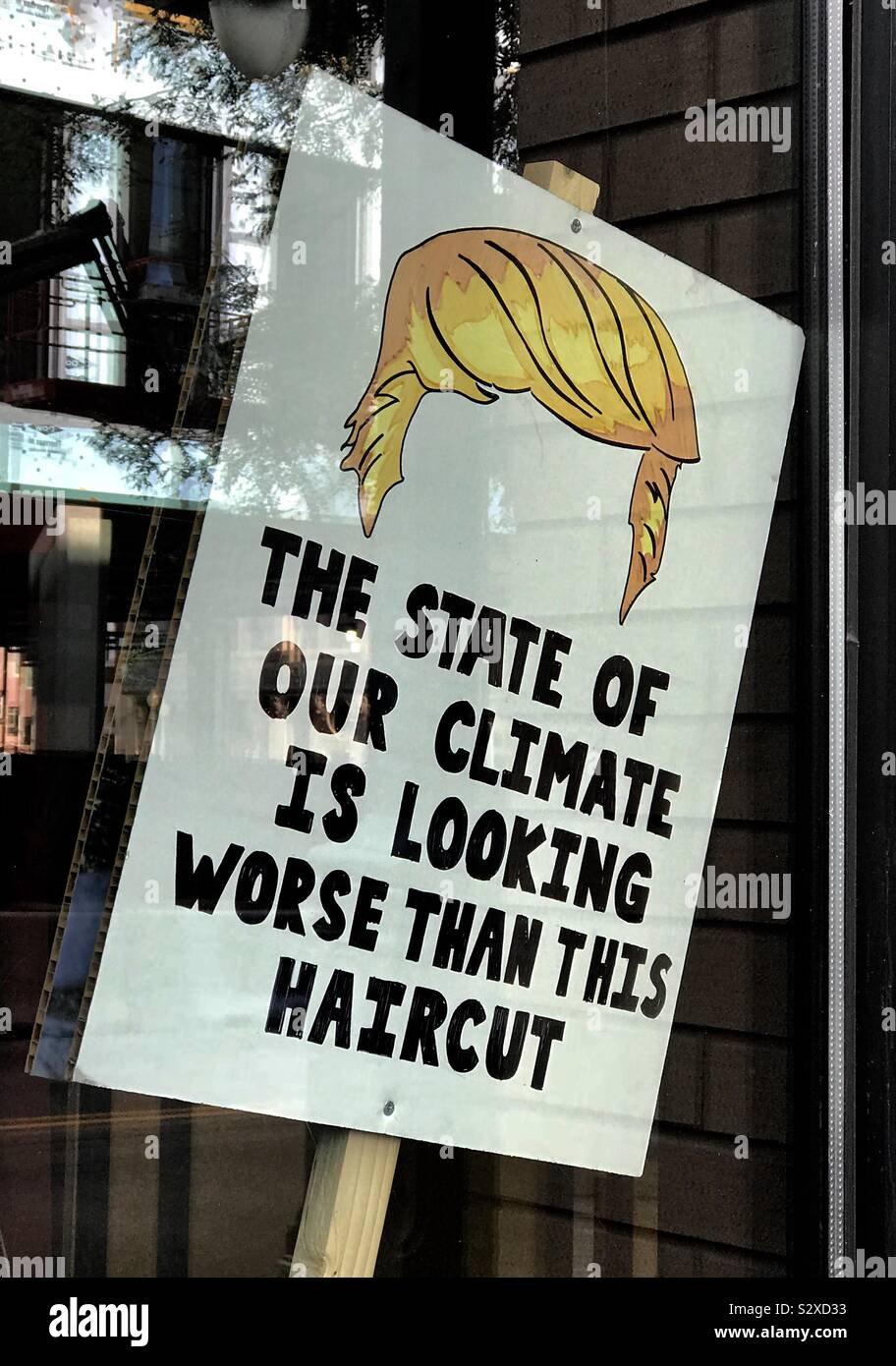 Ein Klimawandel slogan Banner in einem Denver, USA restaurant Fenster nach dem März heute. "Der Zustand unserer Klima sucht Schlimmer als dieses Haarschnitt" in Bezug auf Donald Trump im Besonderen. Stockfoto