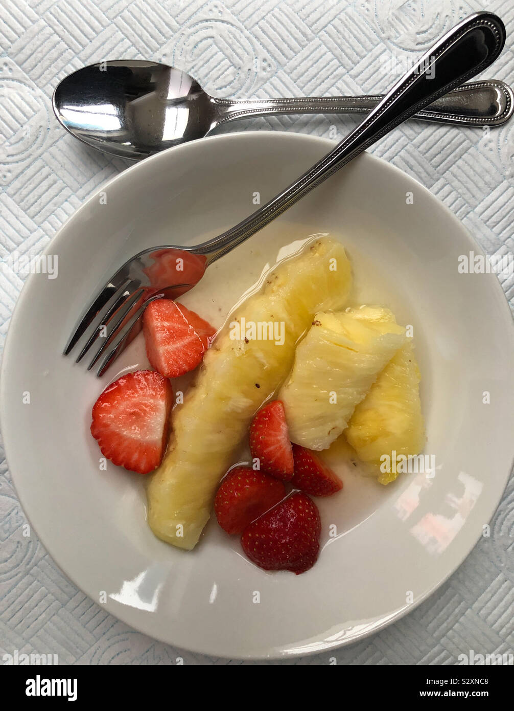 Von oben nach unten in eine Schale mit frischem Obst - Ananas, Erdbeeren - Smartphone-aufgenommenes Stockfoto