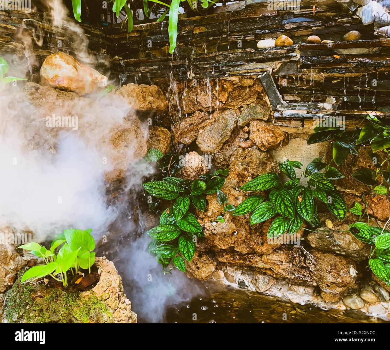 Mann aus Garten Wasserfall mit Rauch Stockfoto