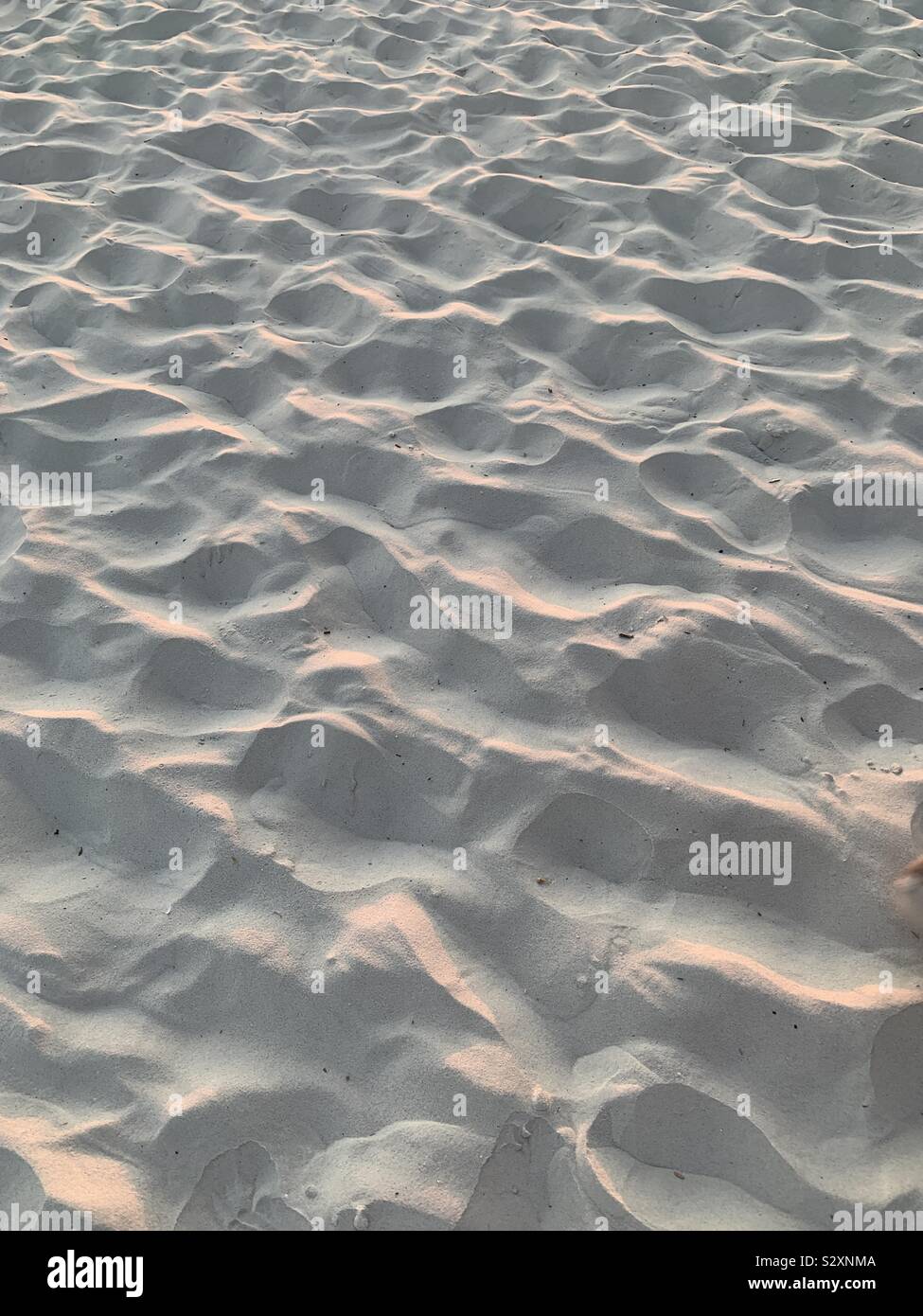 Weißer Sand Texturen und Muster mit Licht von Sonnenuntergang Himmel - Smartphone-aufgenommenes Stockfoto