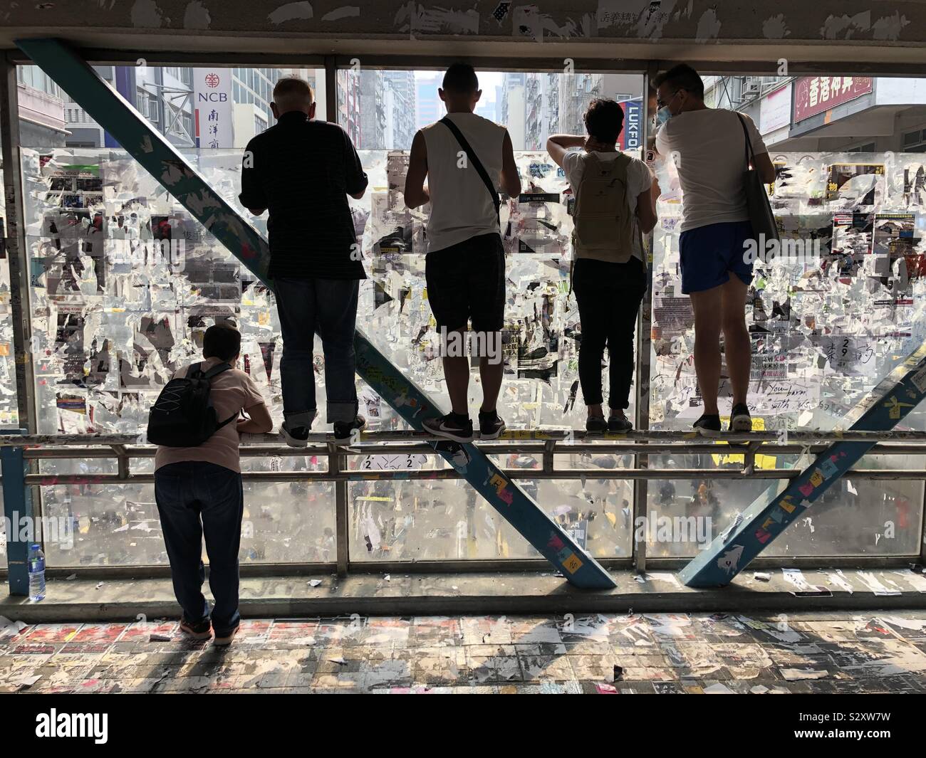 Leute beobachten Demonstranten März von einer Brücke in Causeway Bay, Hong Kong. Stockfoto