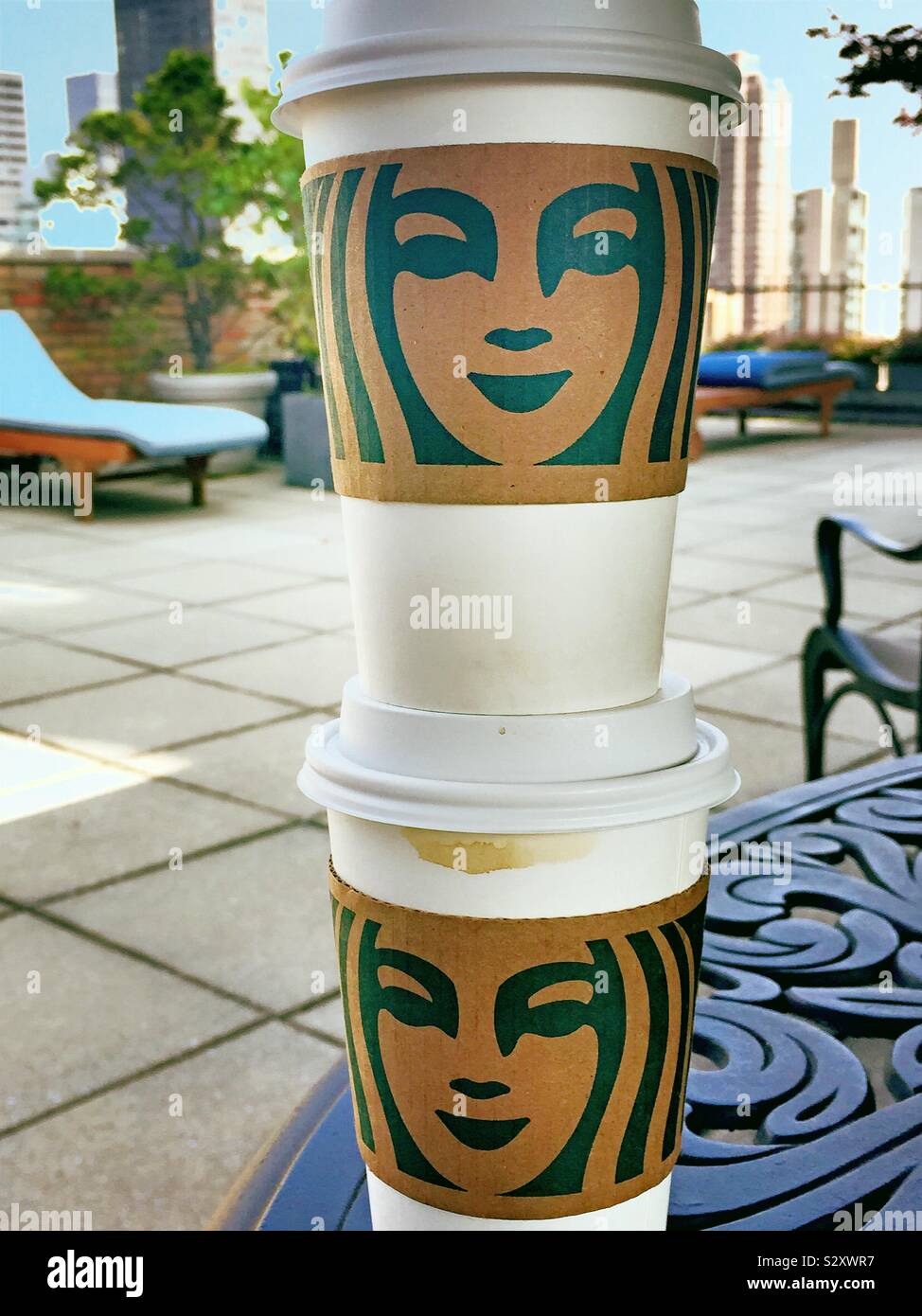 Starbucks Kaffee Tassen auf dem Tisch auf einer Wohnung Haus Dachterrasse in Midtown Manhattan, NYC gestapelt, USA - Smartphone-aufgenommenes Stockfoto