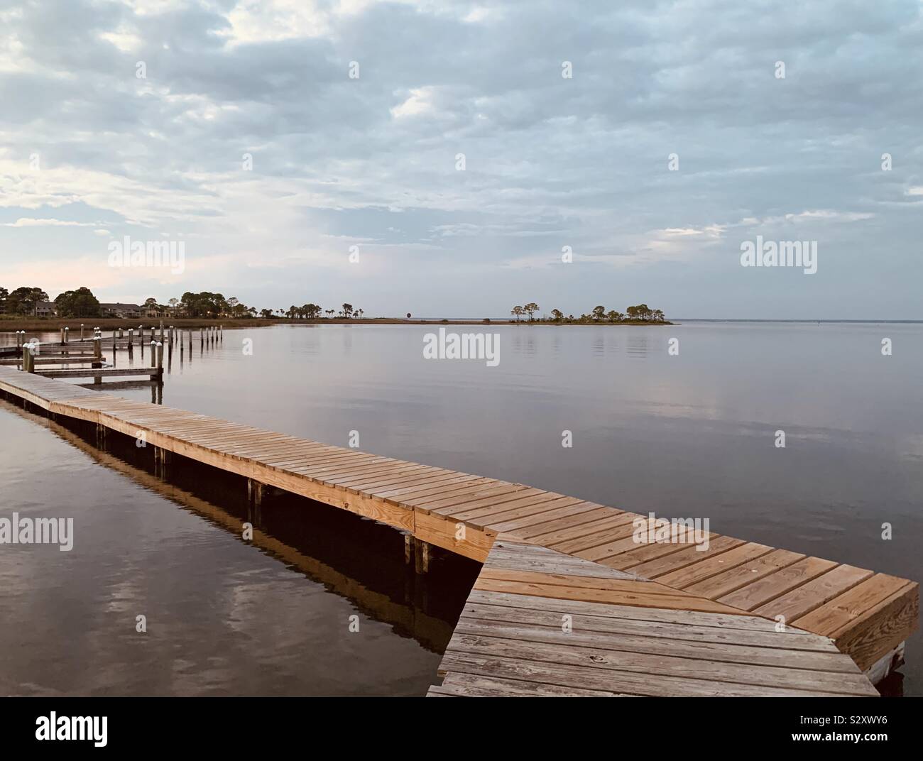 Blick auf die Bucht Wasser mit arbeitsniederlegung Pier und weißen bewölktem Himmel - Smartphone-aufgenommenes Stockfoto