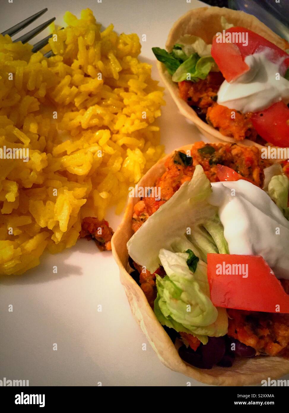 Flach in der Nähe ein mexikanisches Essen von Taco gefüllte tortilla Schüsseln und gelber Reis Stockfoto