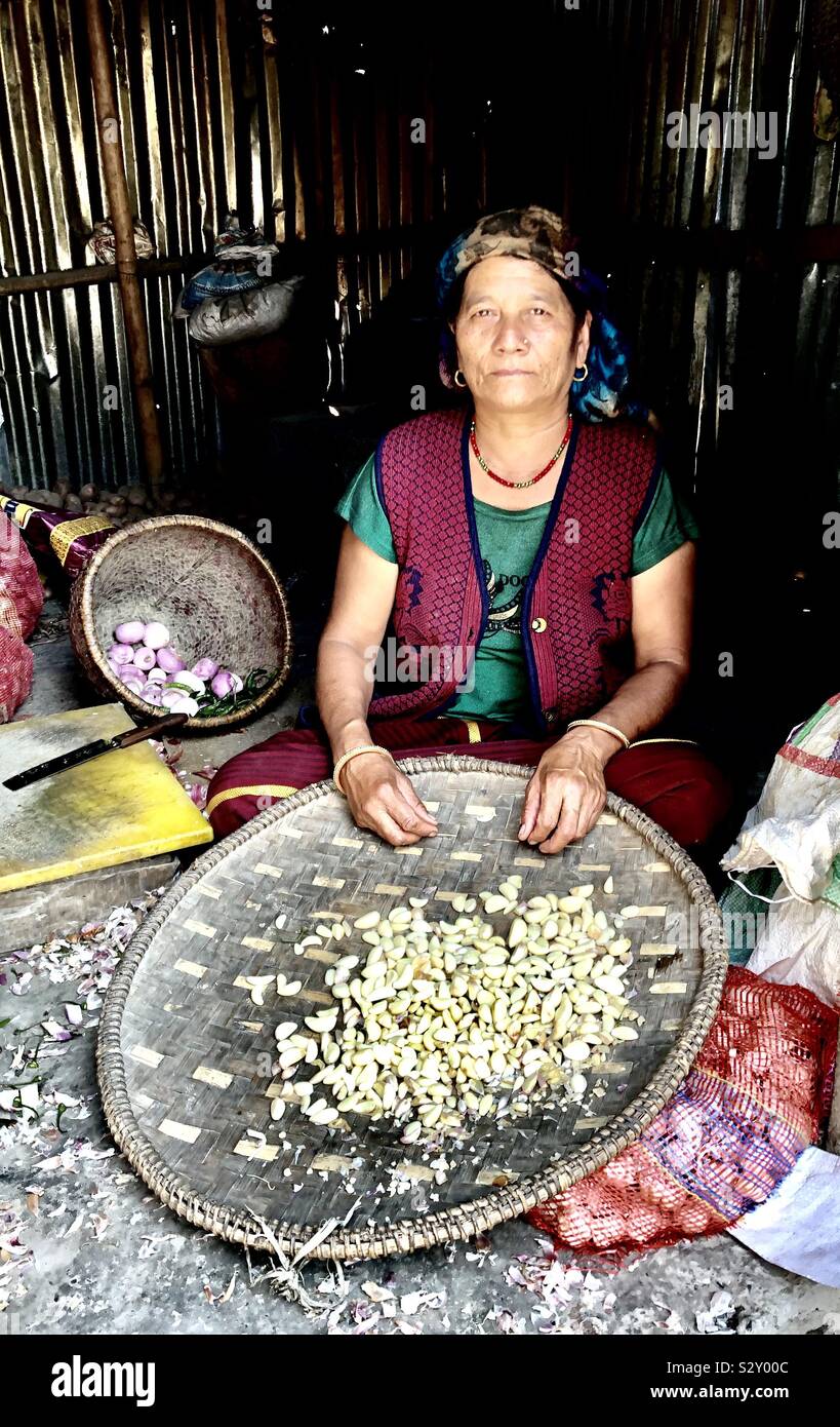 Eine nepalesische Frau Verkauf von Knoblauch und Zwiebeln. Stockfoto