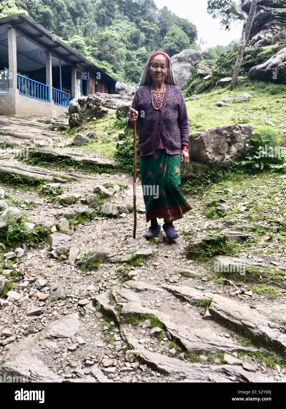 Eine ältere Nepalesische Frau wandern hinunter in die Stadt der Ghorepani in Nepal. Stockfoto