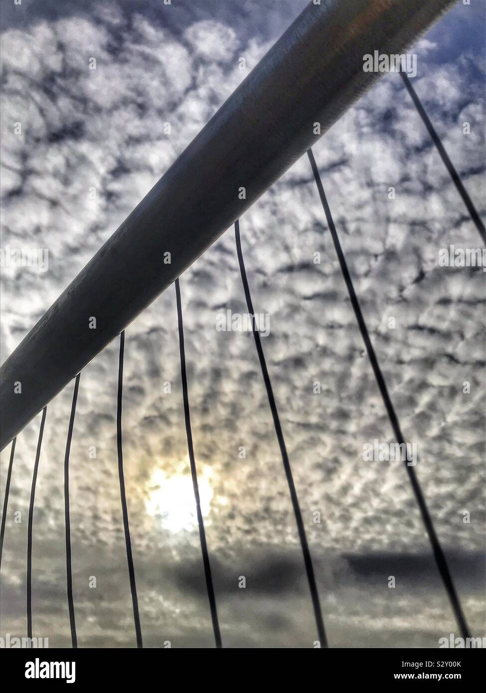 Seltsame Wolkenbildung hinter einem metallbau Zaun Stockfoto