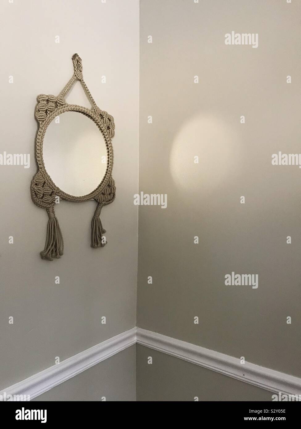 Spiegel in einem handgefertigten Rahmen, reflektierende Licht auf eine Wand Stockfoto