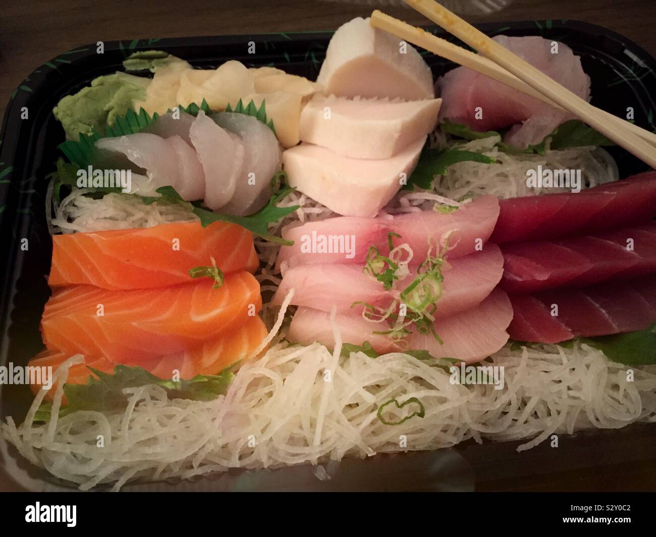 Nahaufnahme eines sortierten sashimi Entrée mit hölzernen Eßstäbchen - Smartphone-aufgenommenes Stockfoto