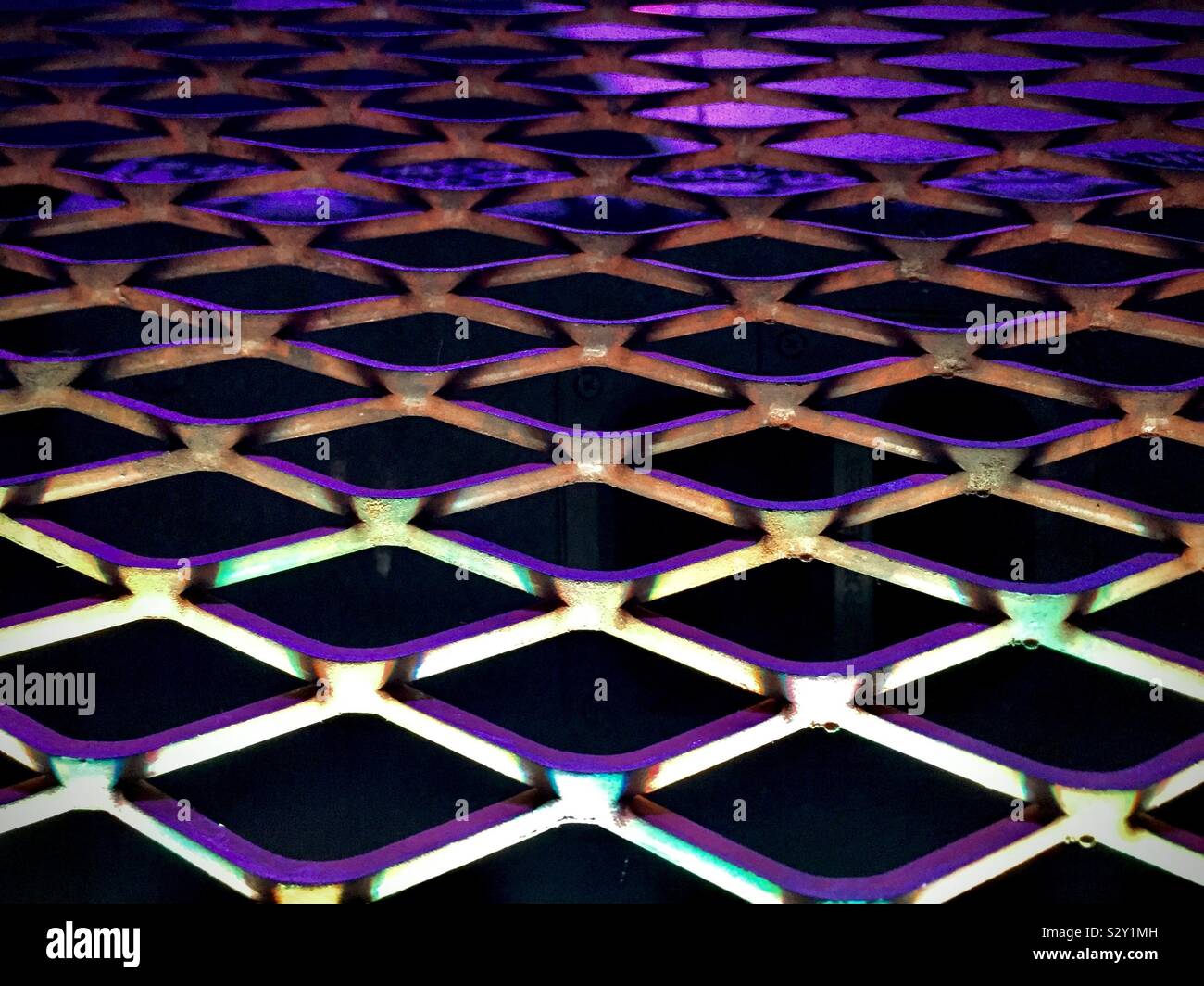 Hintergrund Abstract: Metallgitter mit violetten Lichter in der Nacht Club lit - Smartphone-aufgenommenes Stockfoto