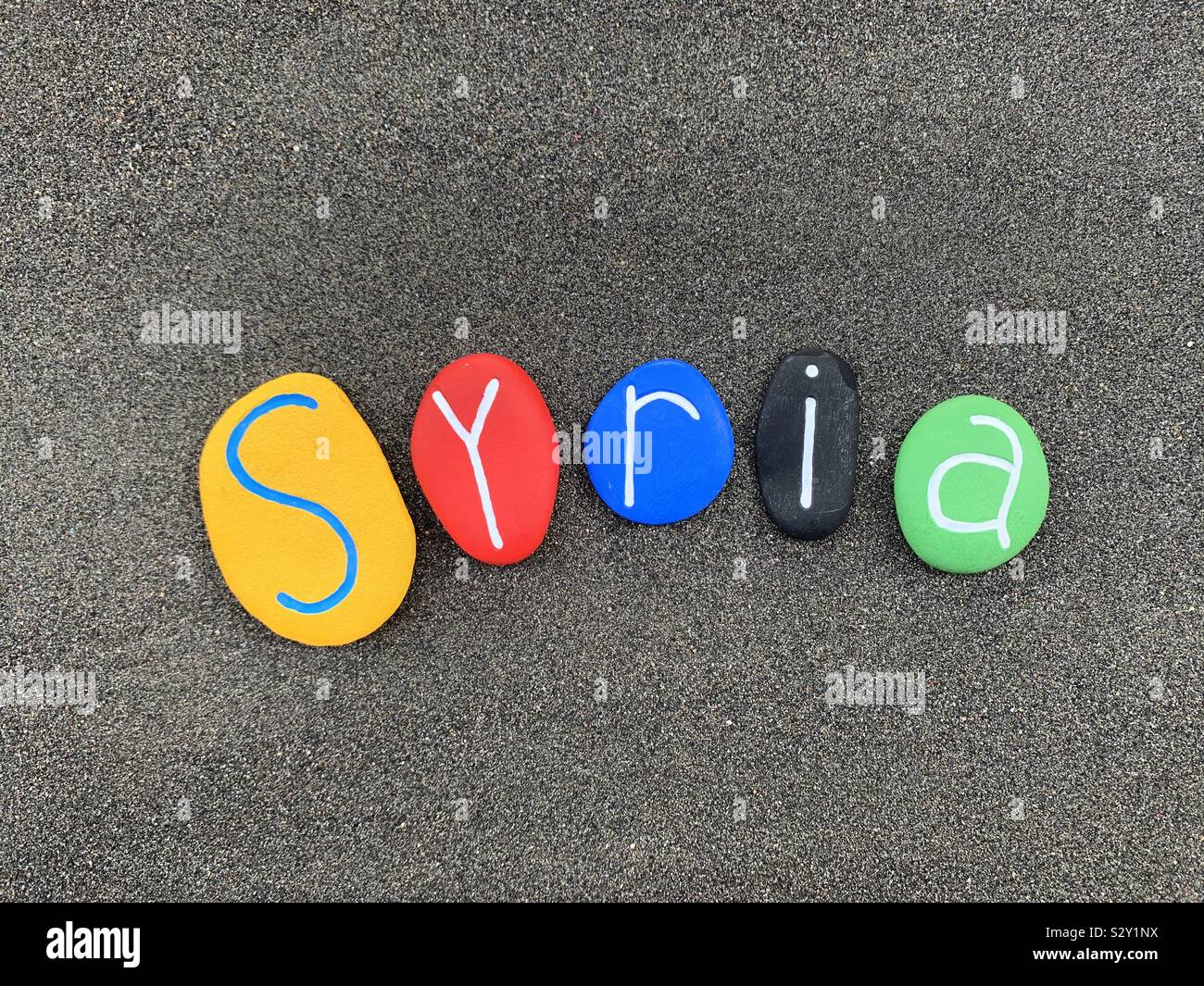 Syrien Land Name besteht aus bunten stein Briefe über schwarzen vulkanischen Sand - Smartphone-aufgenommenes Stockfoto