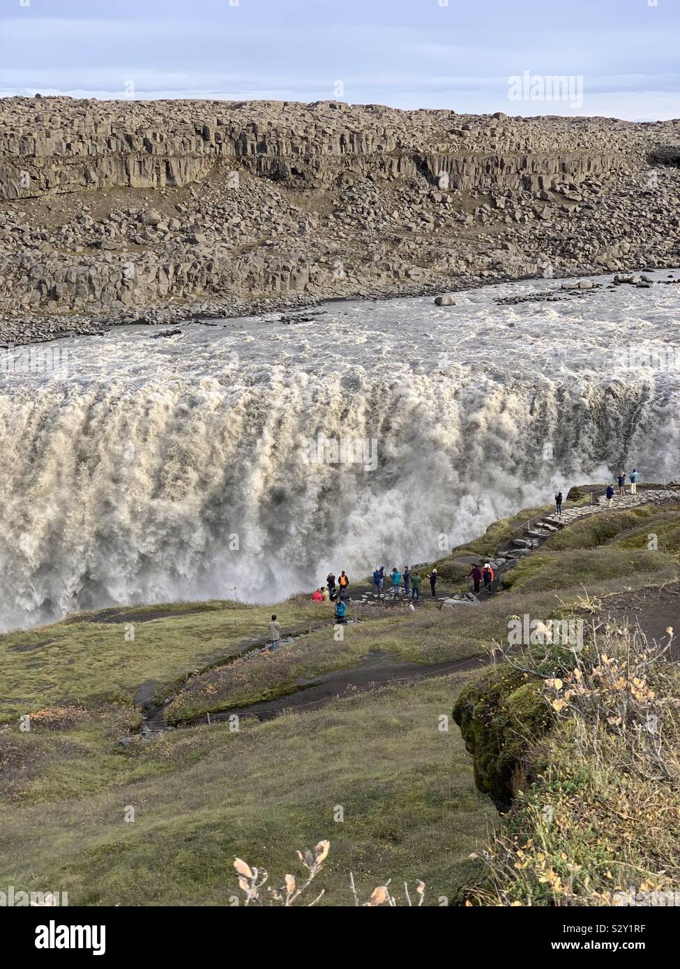 Dettifoss, Island - September 2019: Die Besucher werden von den größten Wasserfall in Island in den Schatten gestellt. Stockfoto
