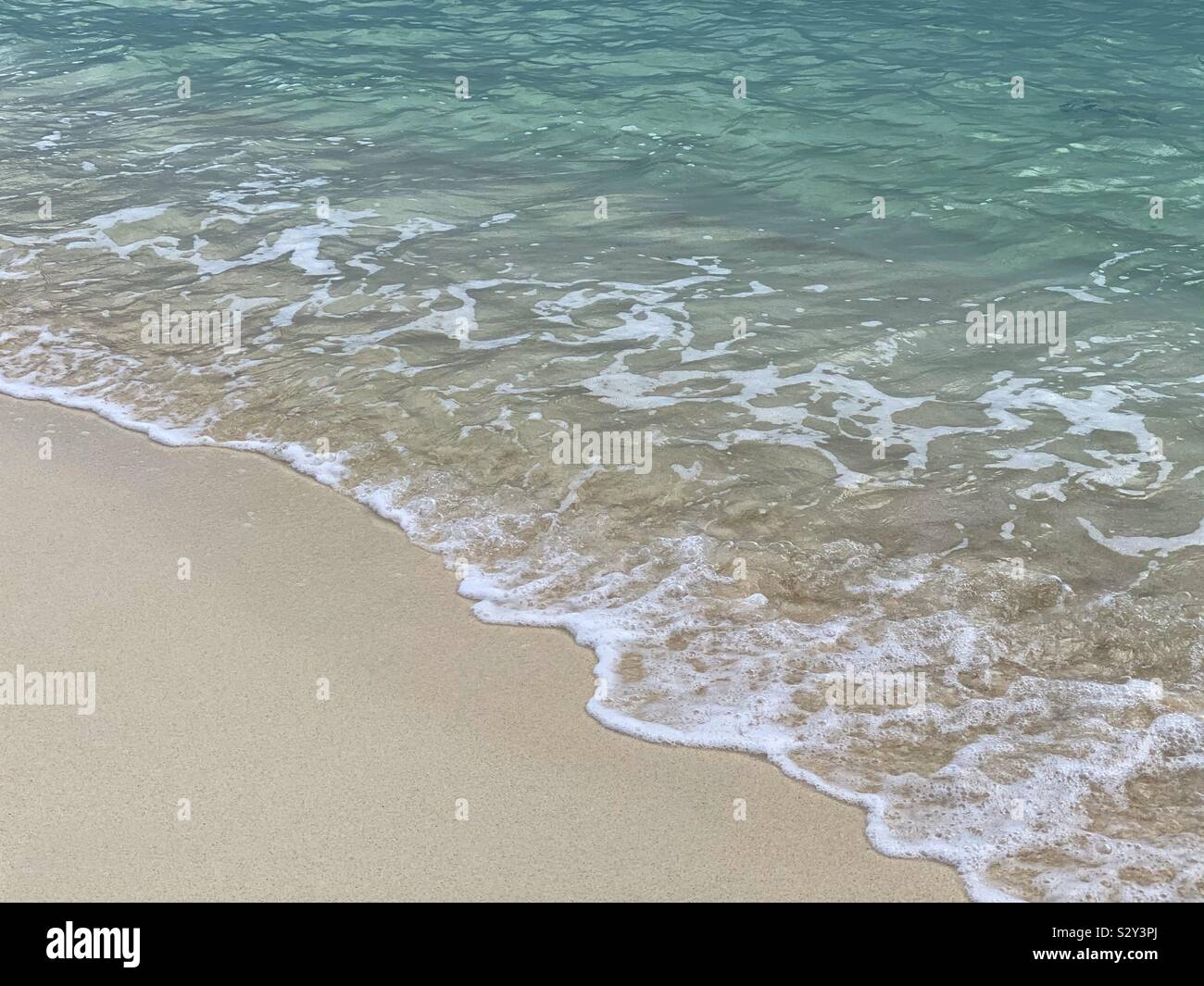 Wo das Meer das Land... Ocean gegen Sand an der Küste am Strand Stockfoto