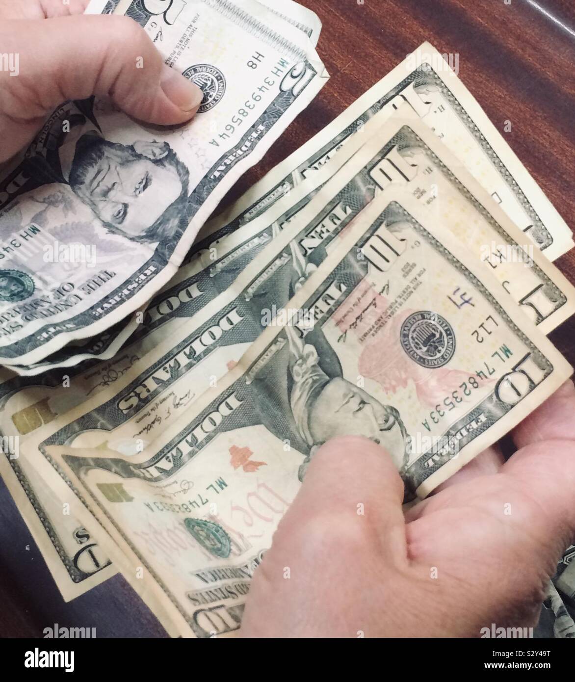 Die Frau Hände Nahaufnahme zählen US-Dollar Banknoten. - Smartphone-aufgenommenes Stockfoto