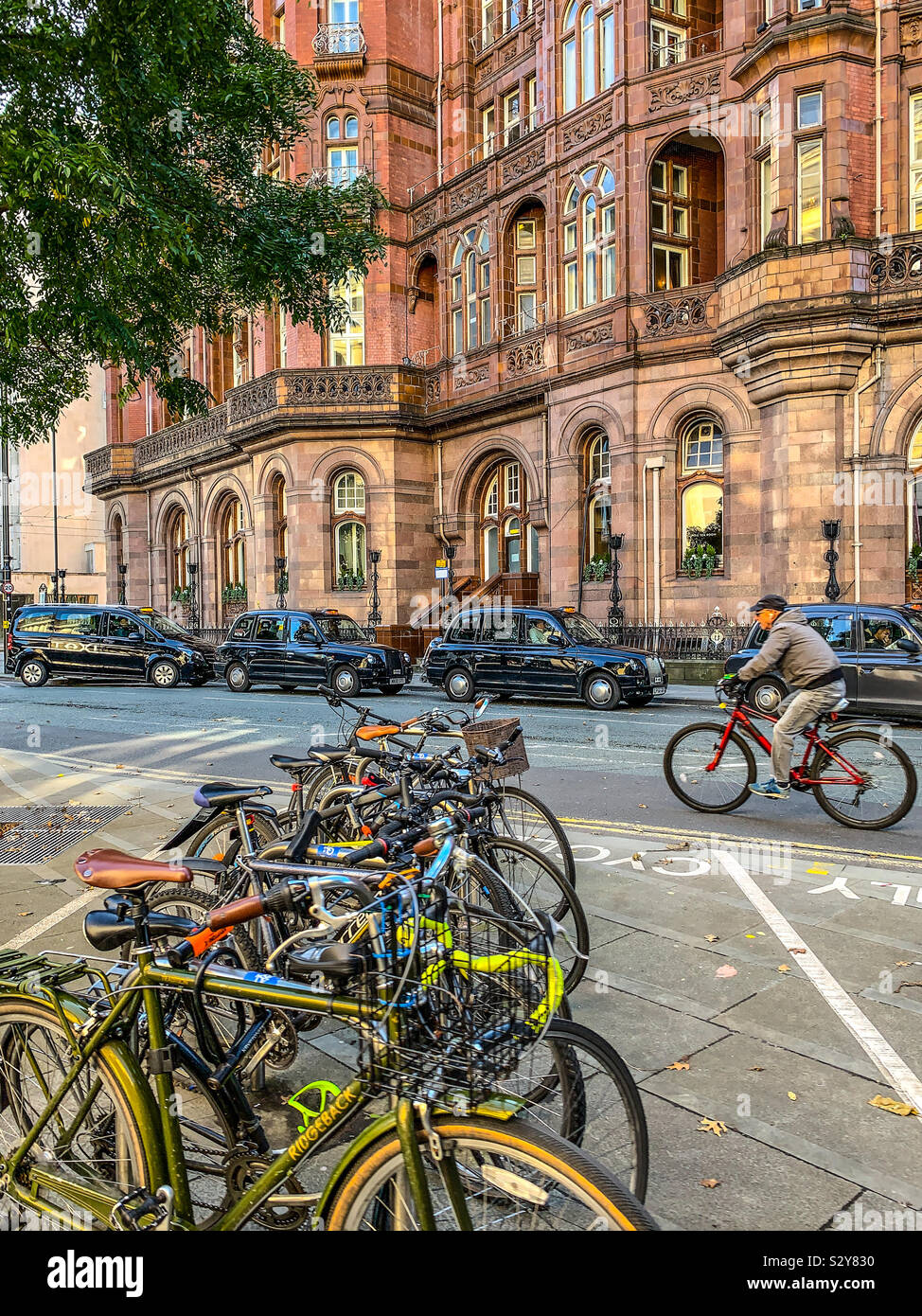 Fahrräder und schwarzen Taxis außerhalb des Midland Hotel in Manchester. Stockfoto