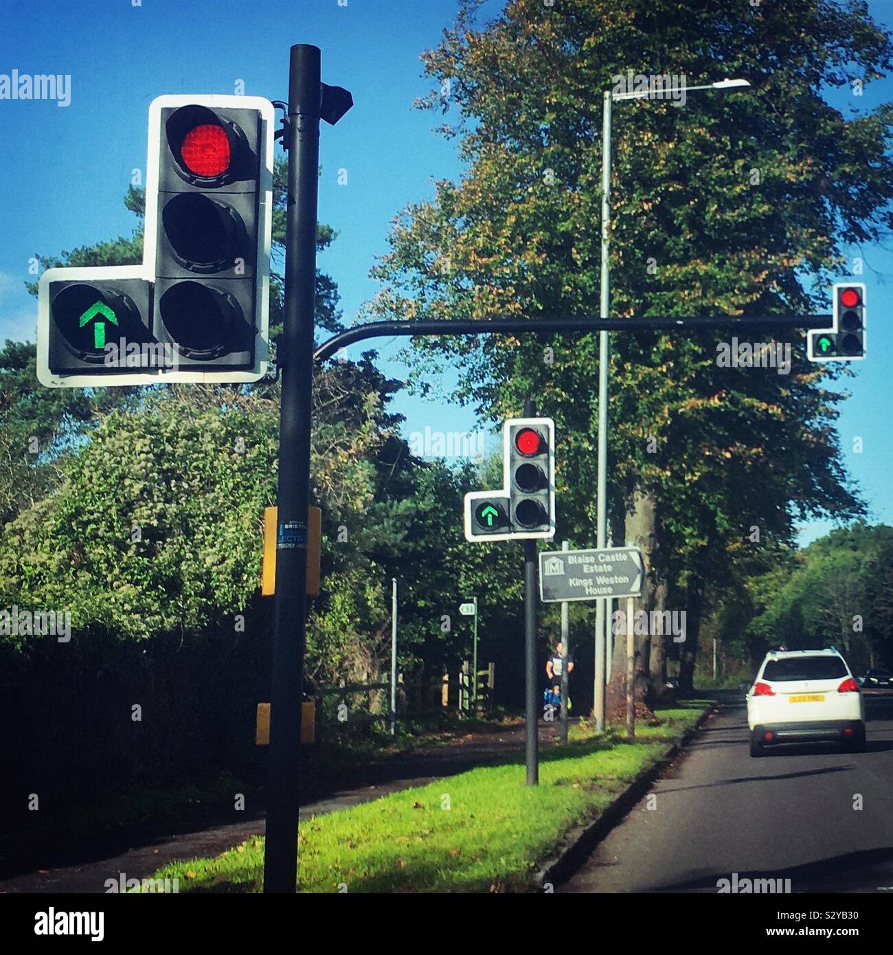 Mehrere Ampeln auf Rot mit einem grünen Pfeil, in Großbritannien Stockfoto