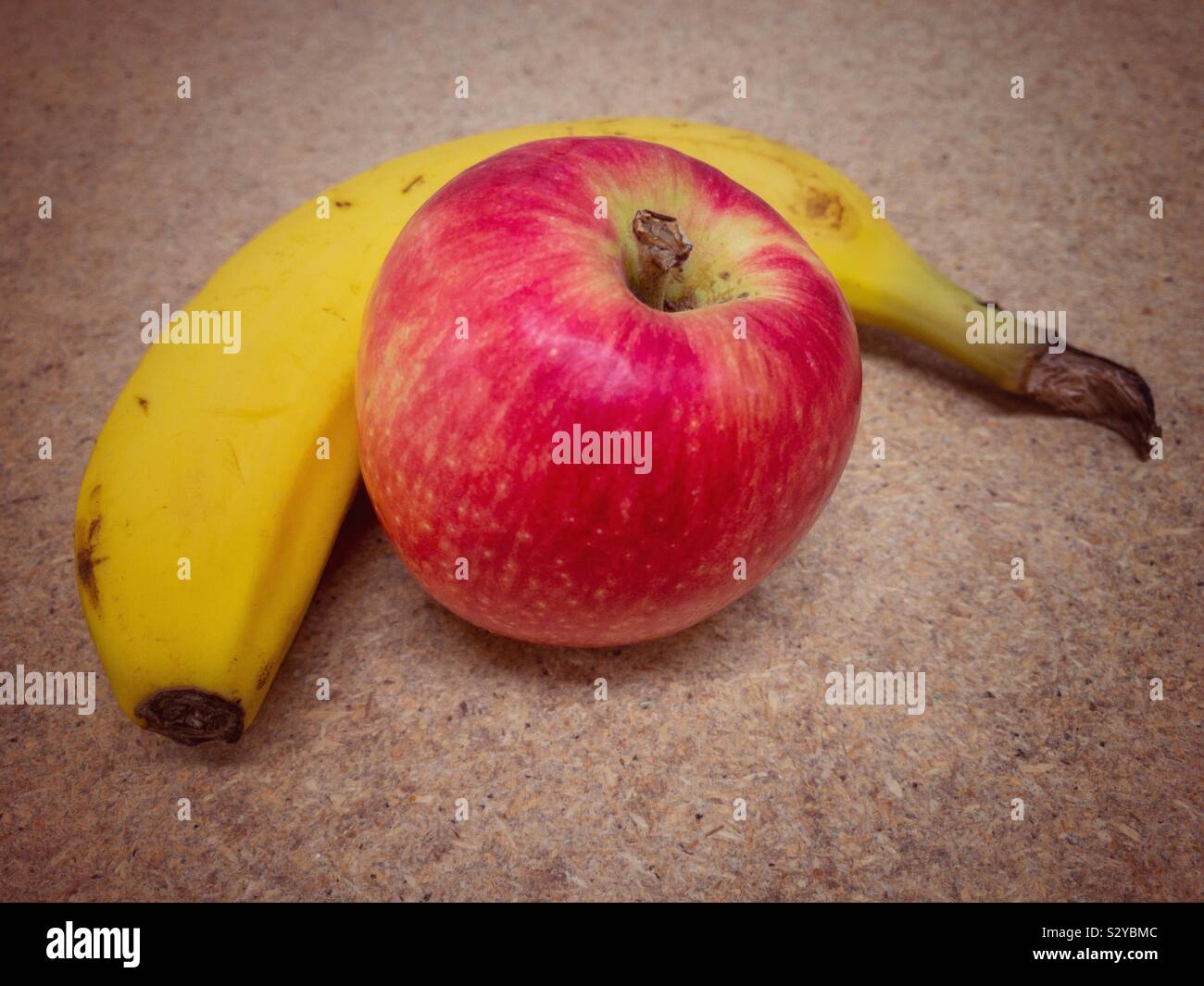 Eine Banane und einen Apfel auf dem Tisch. Stockfoto