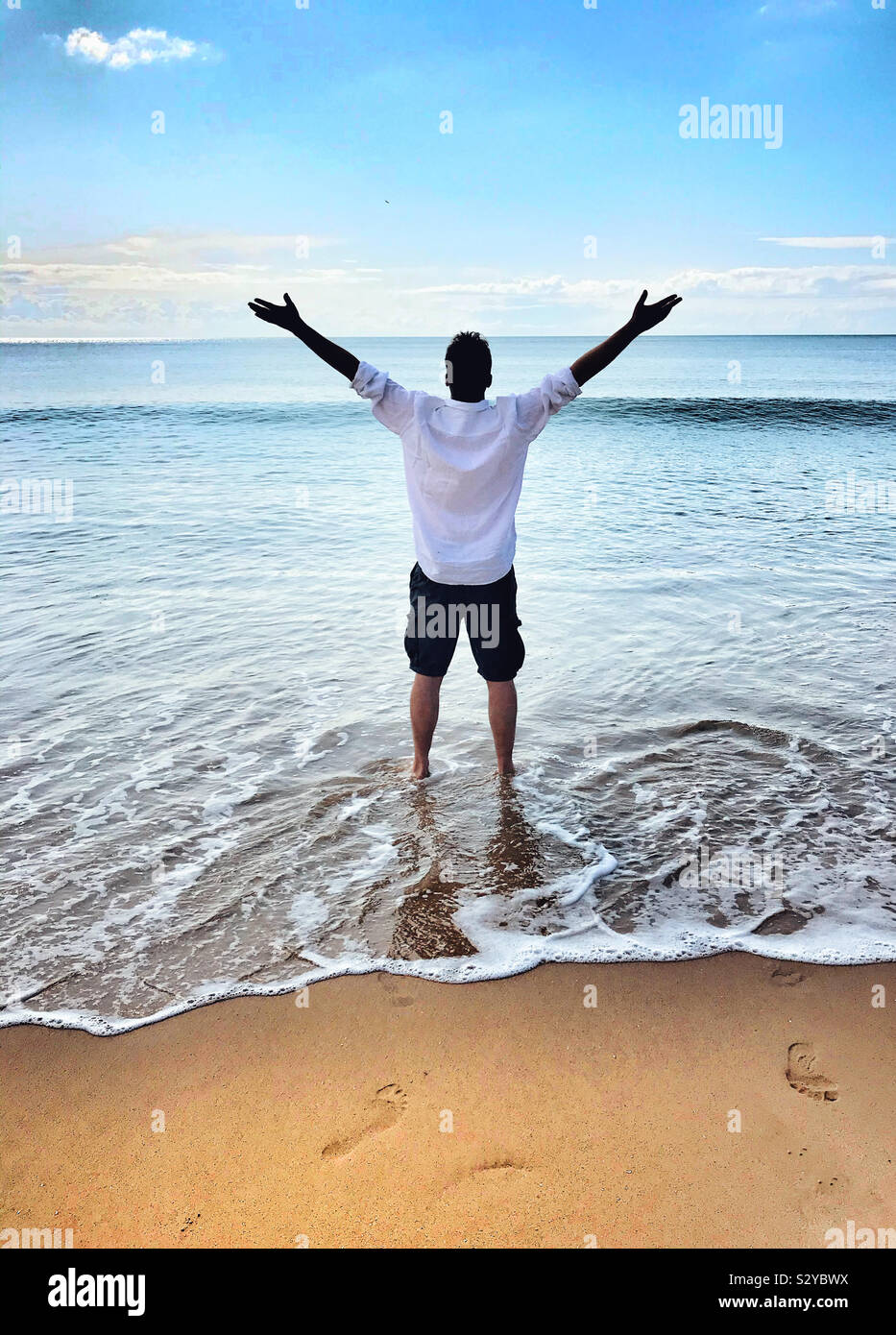 Mann im Meer heben skywards von seinem Arm Stockfoto