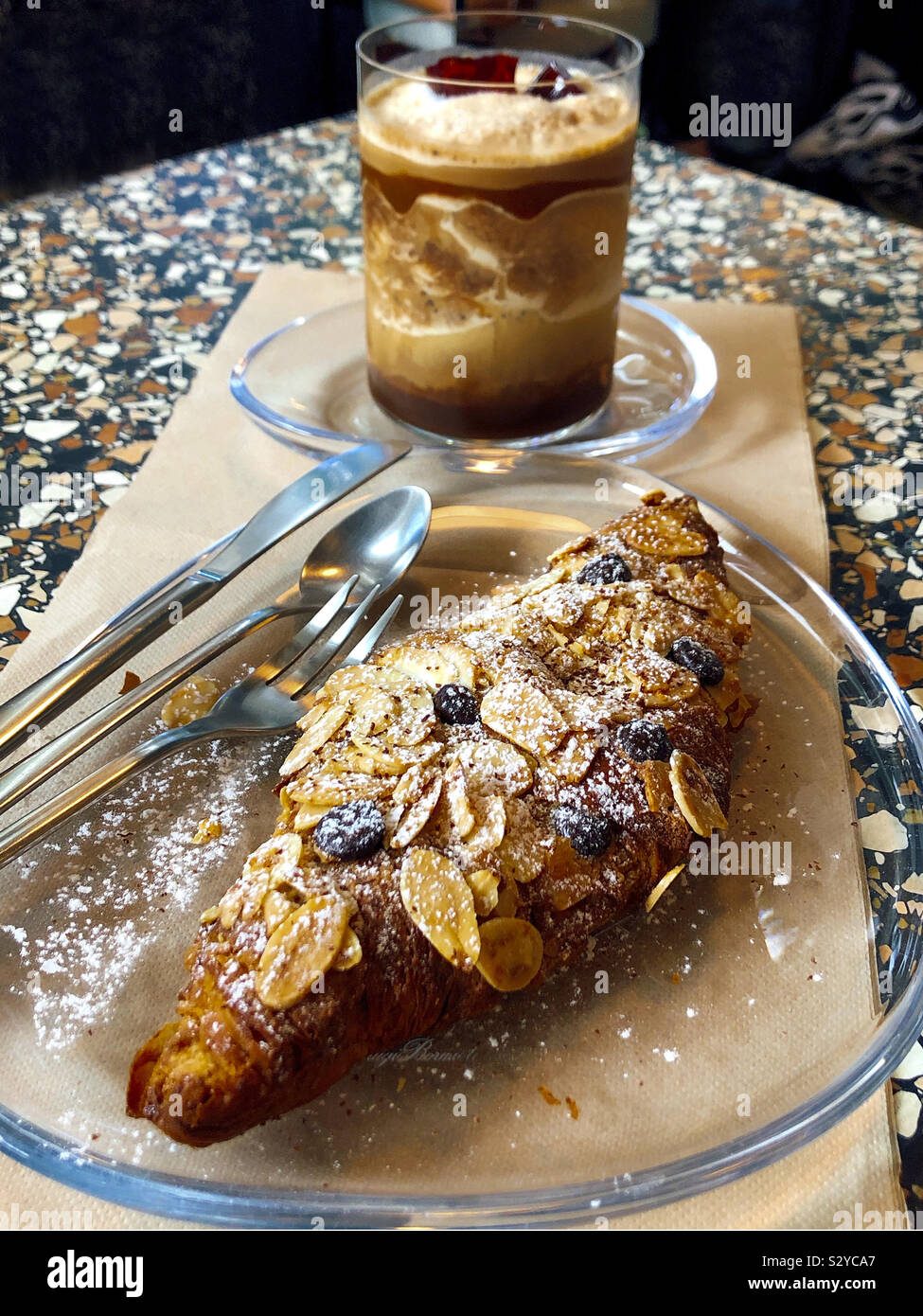 Kaffee und Mandel Croissant auf Tisch Stockfoto