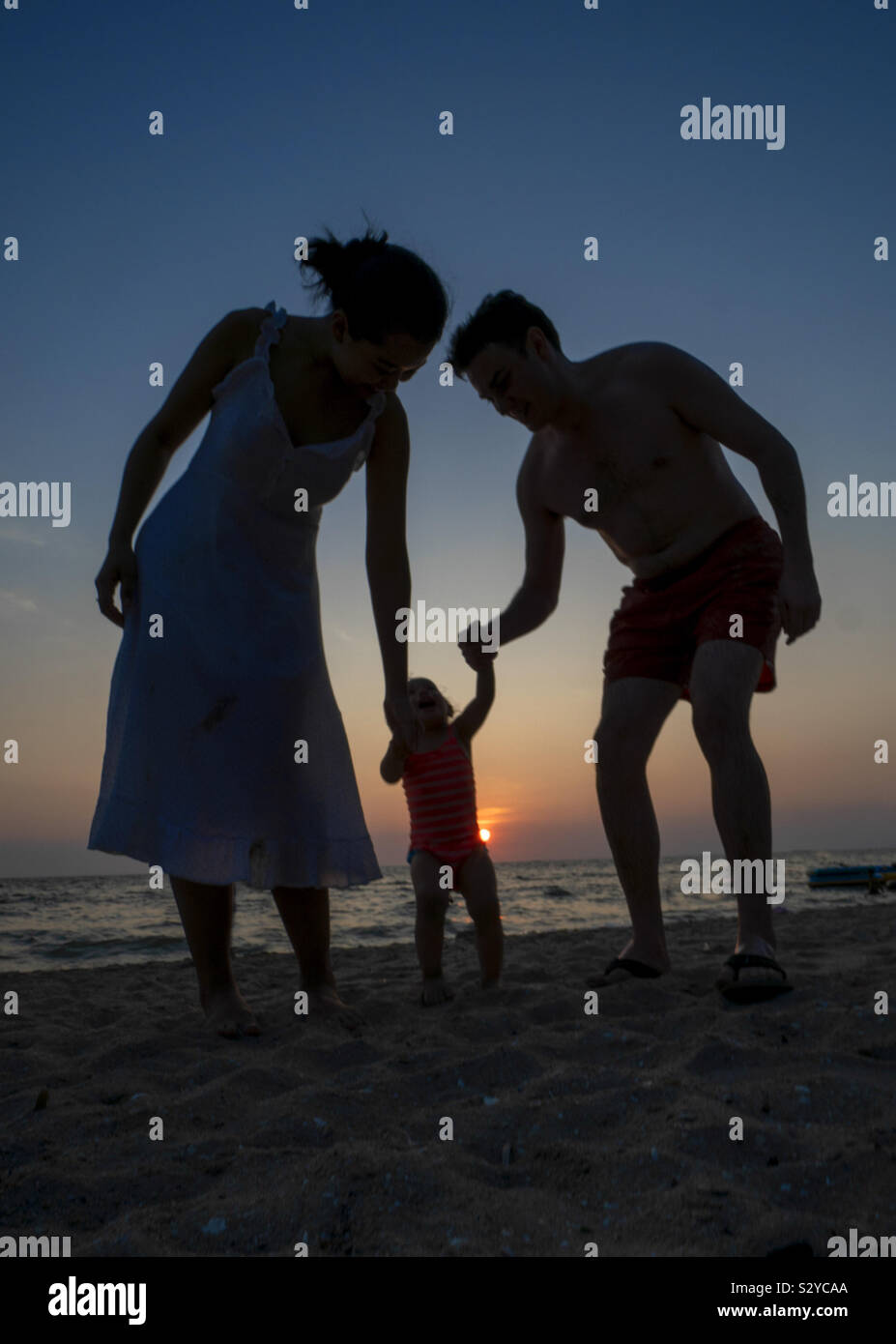 Junge Familie Abendspaziergang am Strand Stockfoto